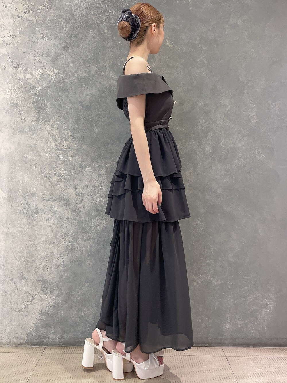 グレー系のワンピース、ホワイト系のサンダル、グレー系のシュシュを着用したレディースの夏コーディネートの2枚目の写真