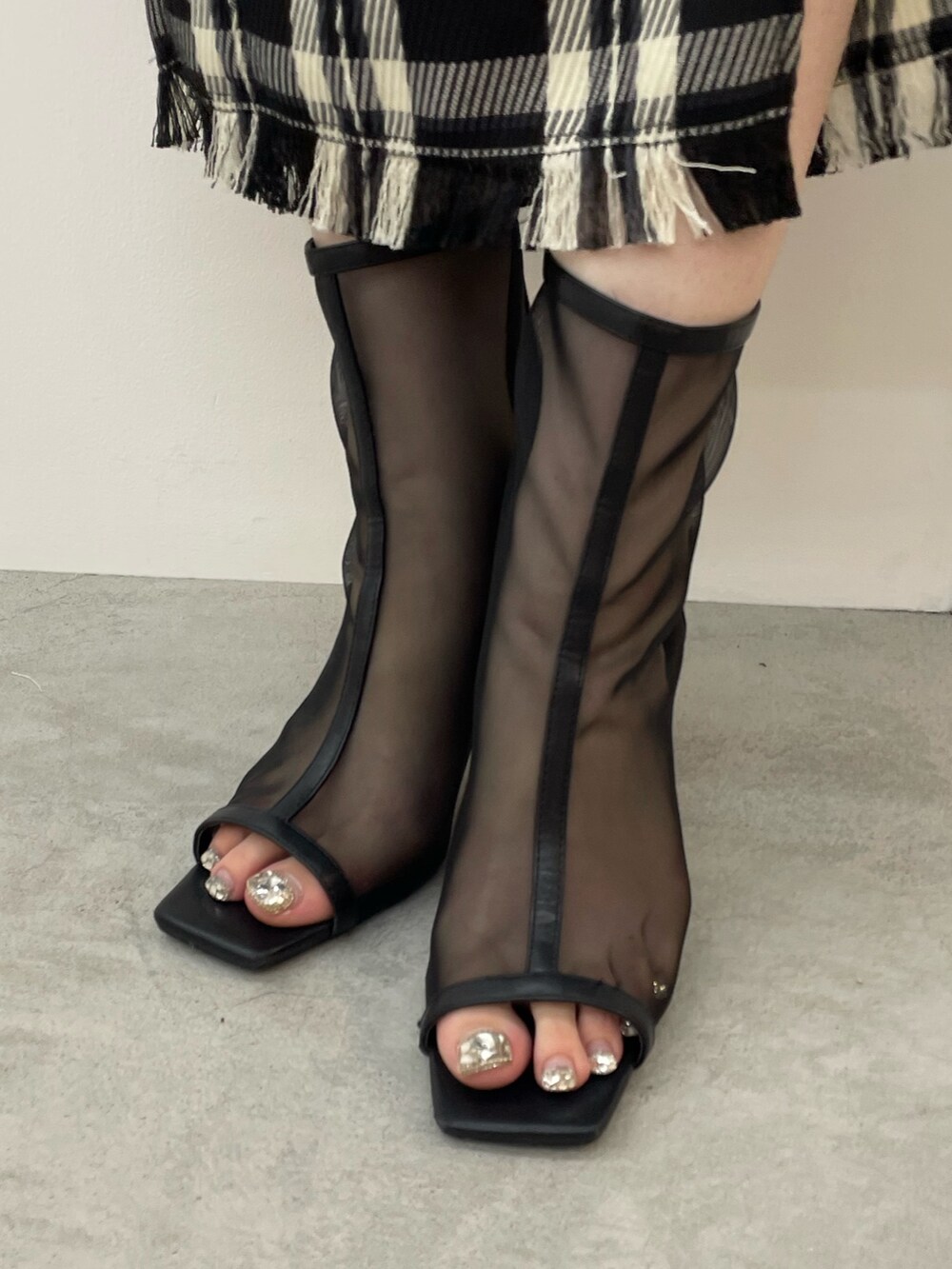 ブラック系のニット/セーター、ブラック系のスカート、ブラック系のハンドバッグを着用したレディースの夏コーディネートの9枚目の写真