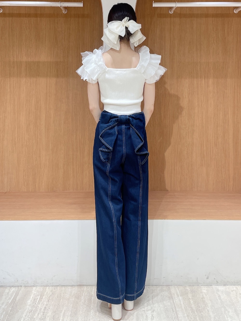 ホワイト系のニット/セーター、ブルー系のデニムパンツ、ホワイト系のサンダルを着用したレディースの春コーディネートの4枚目の写真