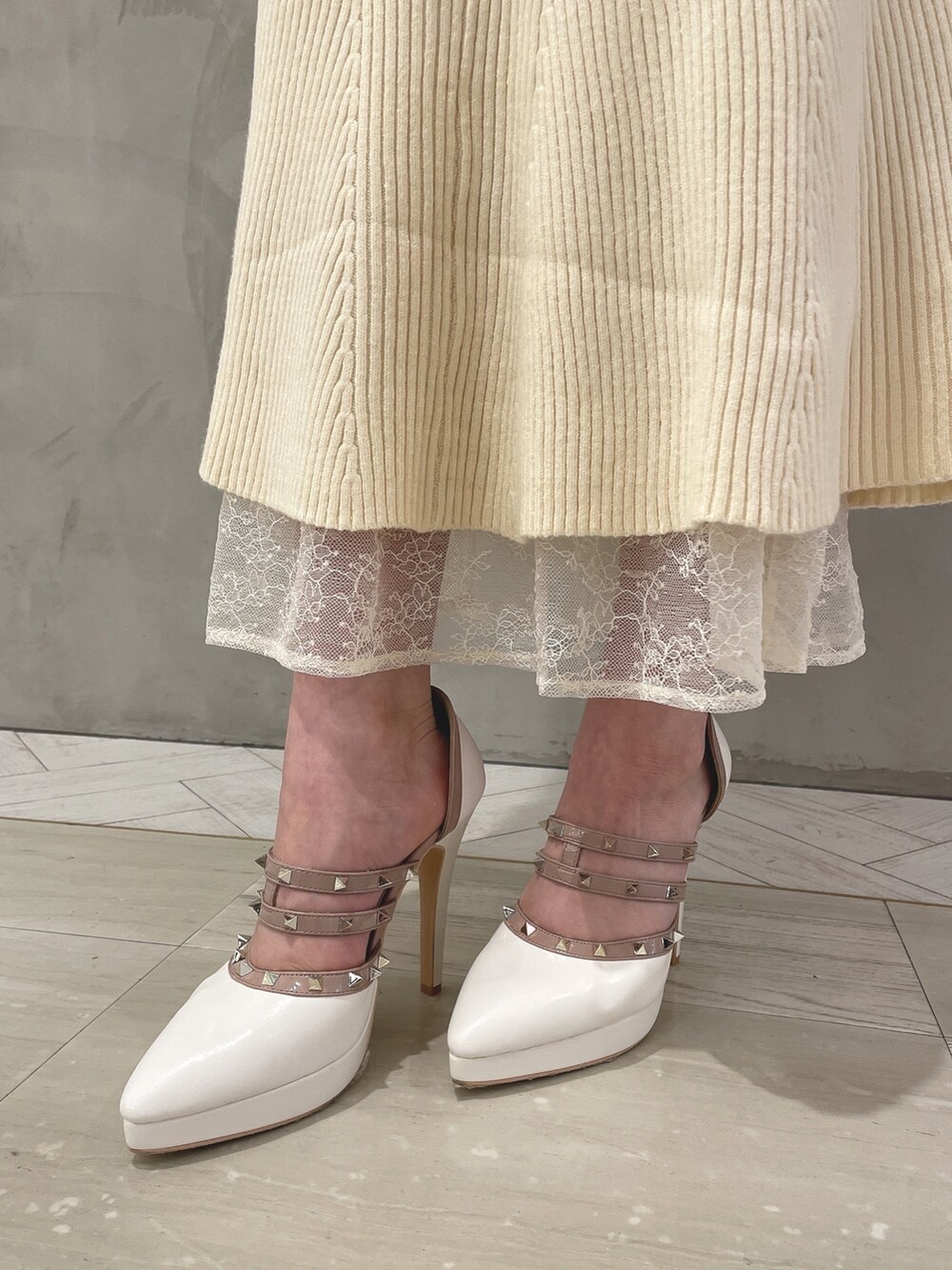 ホワイト系のワンピース、ホワイト系のパンプス、ブラウン系のハンドバッグを着用したレディースの秋コーディネートの7枚目の写真