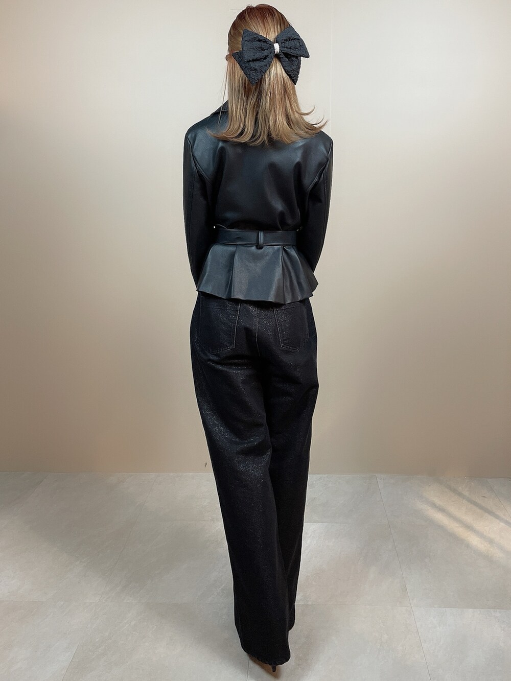 ブラック系のライダースジャケット、ブラック系のデニムパンツ、ブラック系のパンプスを着用したレディースの冬コーディネートの4枚目の写真