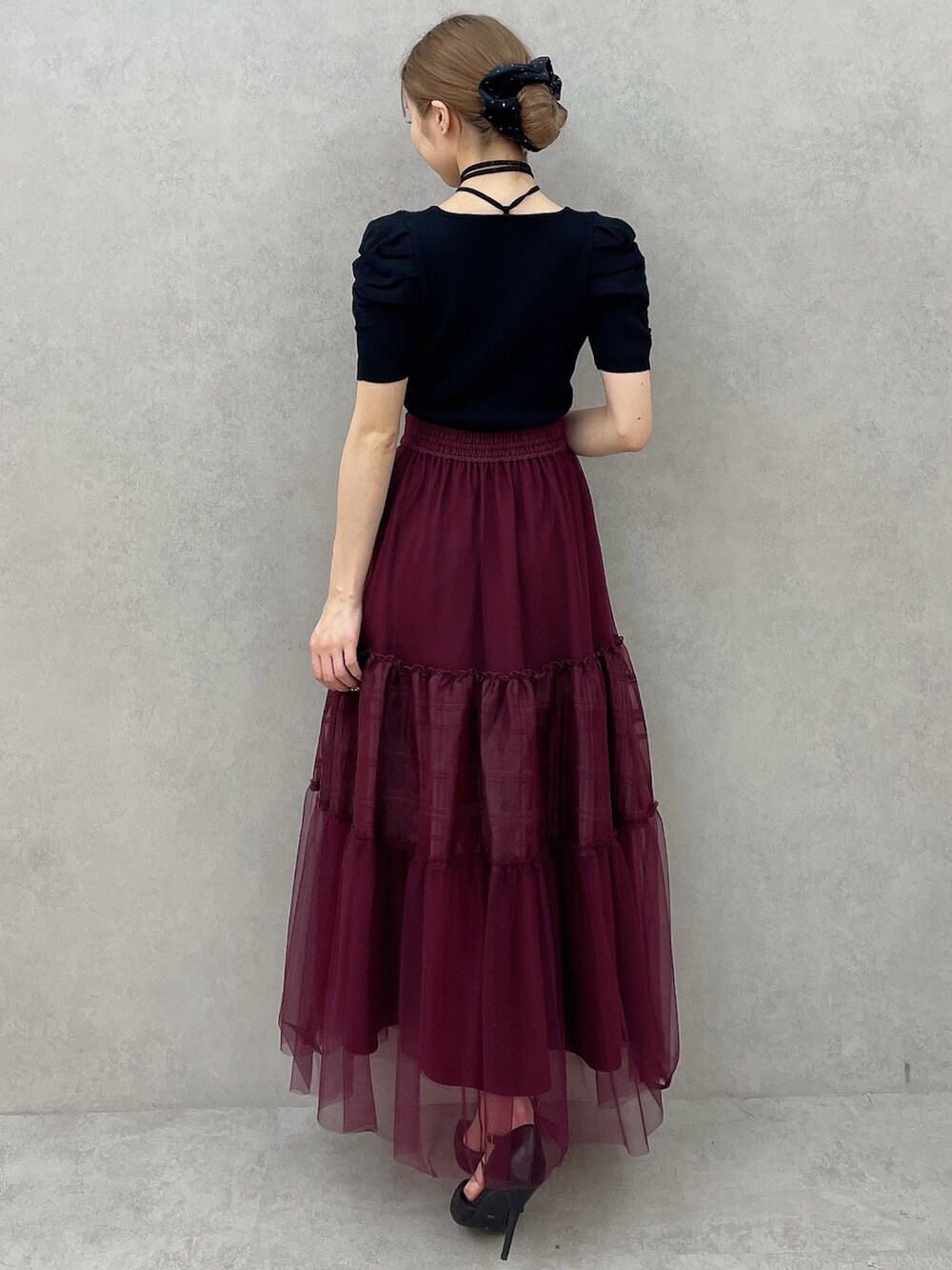 ブラック系のニット/セーター、レッド系のスカート、ブラック系のパンプスを着用したレディースの夏コーディネートの5枚目の写真