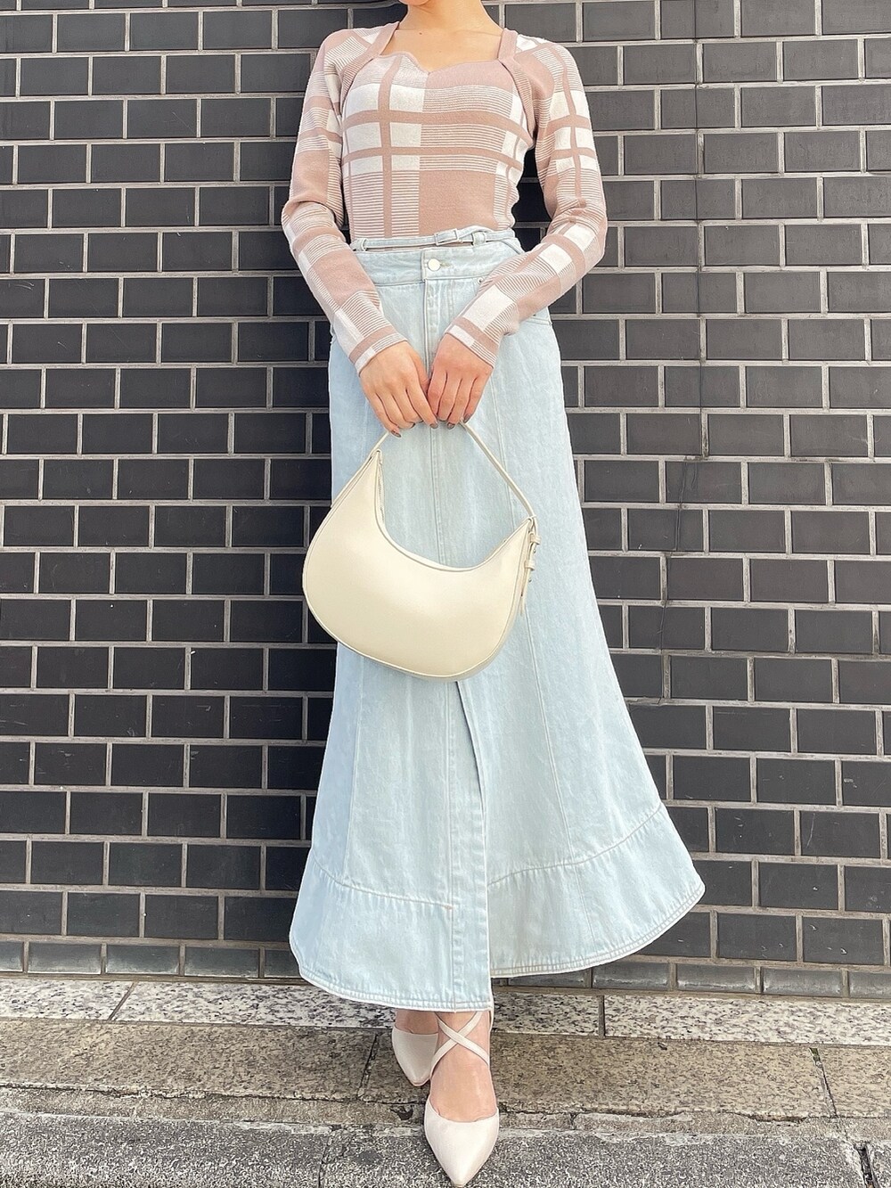 その他のニット/セーター、ホワイト系のハンドバッグ、ブルー系のデニムスカートを着用したレディースの冬コーディネートの3枚目の写真