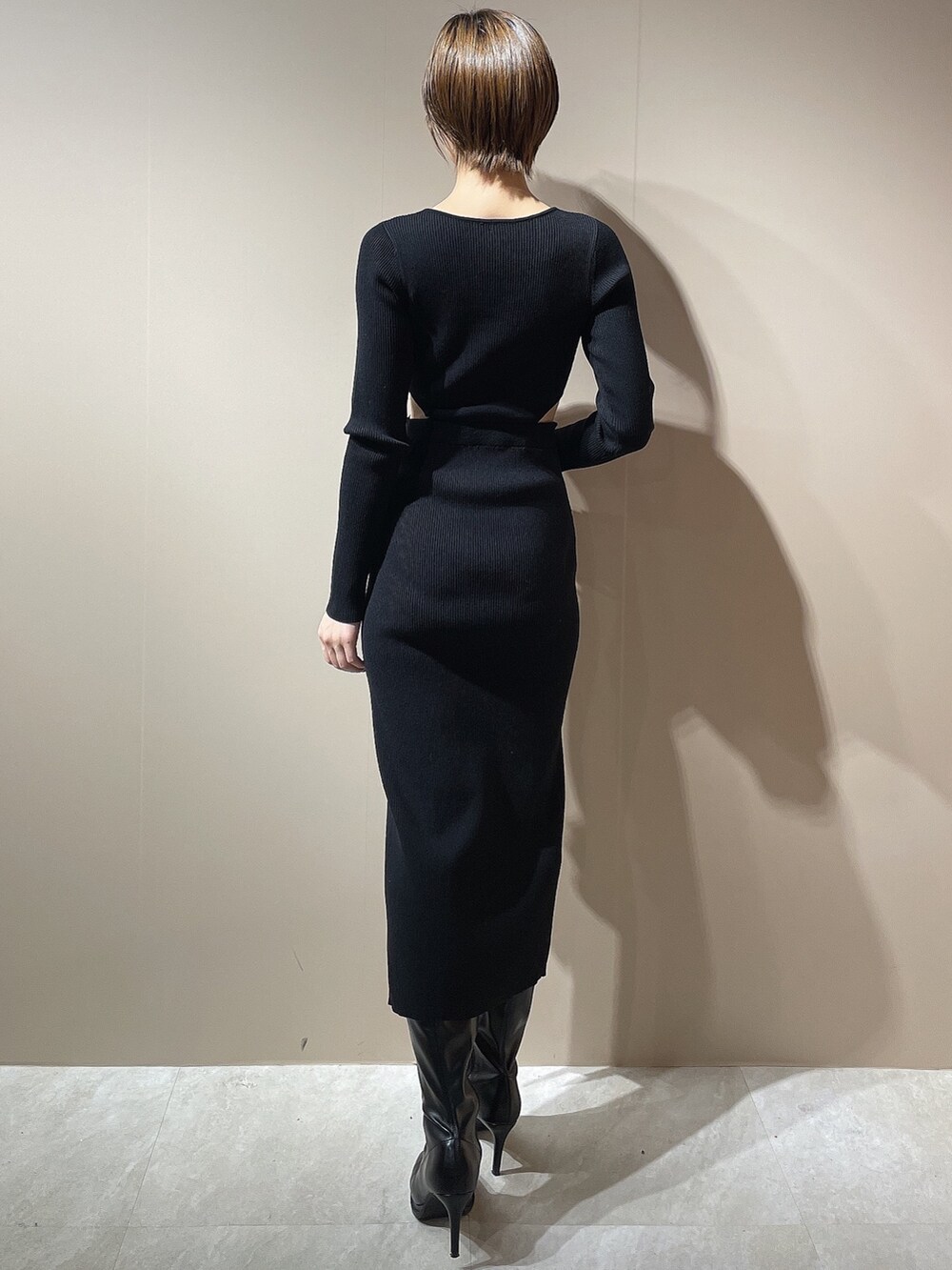 ブラック系のワンピース、ブラック系のダウンジャケット/コート、ブラック系のブーツを着用したレディースの秋コーディネートの3枚目の写真