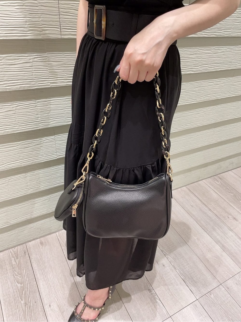 ブラック系のパンプス、ブラック系のニット/セーター、ブラック系のスカートを着用したレディースの春コーディネートの10枚目の写真