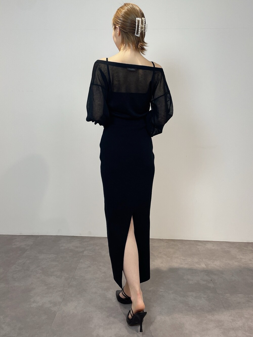 ブラック系のワンピース、ブラック系のパンプスを着用したレディースの冬コーディネートの4枚目の写真