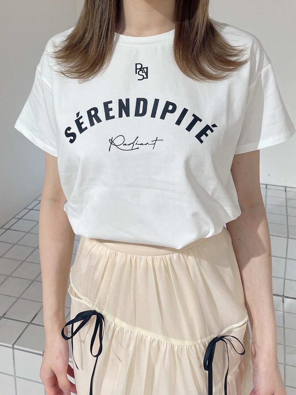 ホワイト系のTシャツ/カットソー、ホワイト系のスカート、ブラック系のパンプスを着用したレディースの夏コーディネートの5枚目の写真