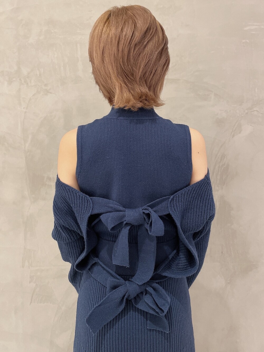 ブルー系のワンピース、ブラック系のブーツ、ブラック系のハンドバッグを着用したレディースの秋コーディネートの6枚目の写真