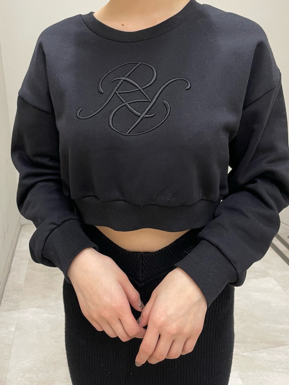 ホワイト系のスニーカー、ブラック系のスウェット、ブラック系のスカートを着用したレディースの冬コーディネートの6枚目の写真