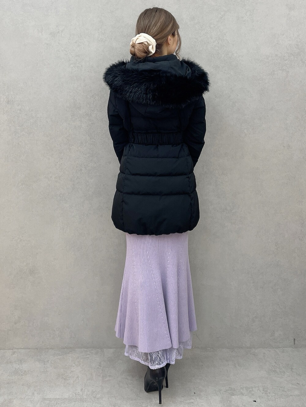 ブラック系のダウンジャケット/コート、パープル系のワンピース、ブラック系のハンドバッグを着用したレディースの秋コーディネートの4枚目の写真