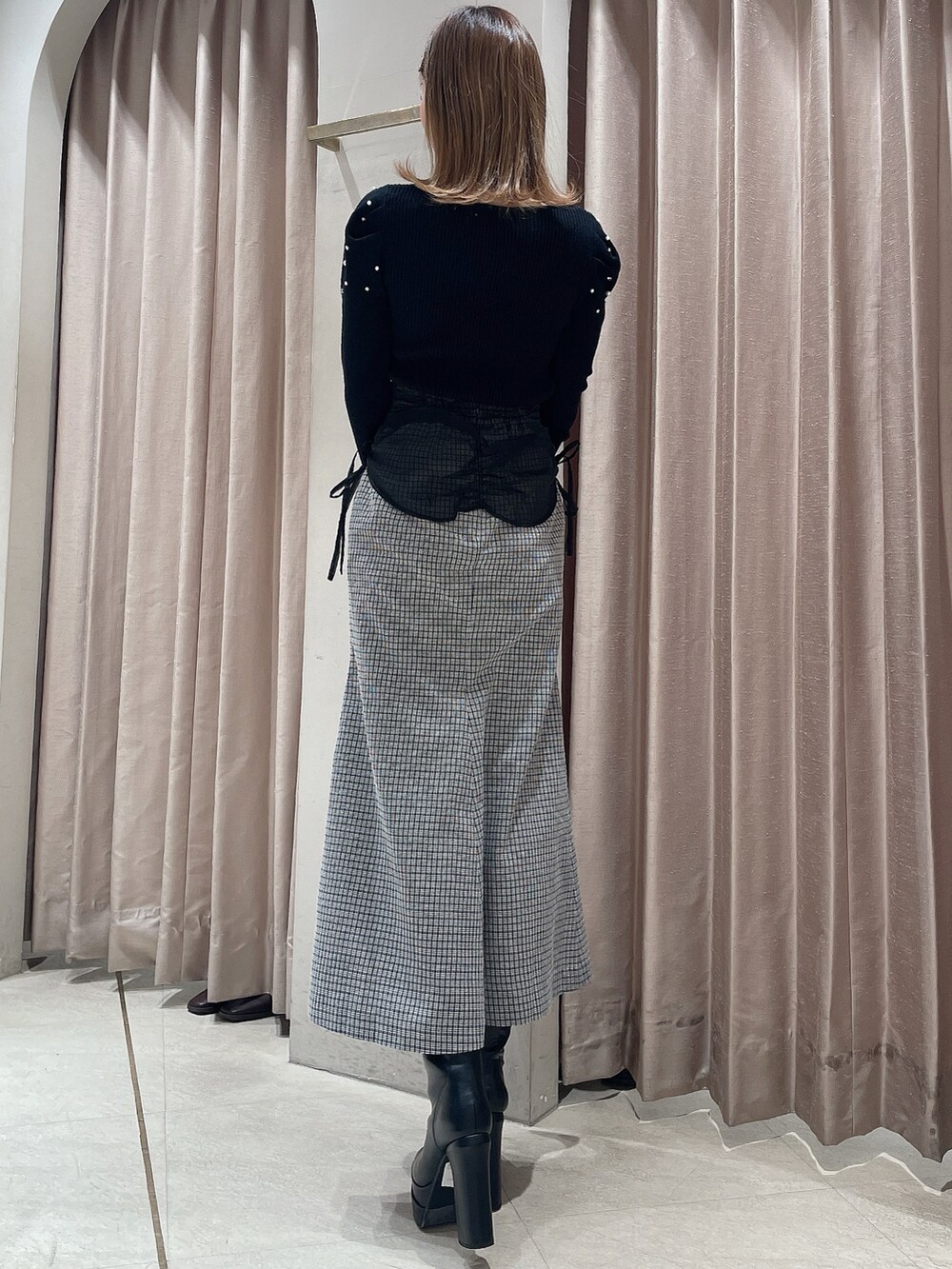 ブラック系のニット/セーター、その他のスカート、ブラック系のブーツを着用したレディースの冬コーディネートの3枚目の写真