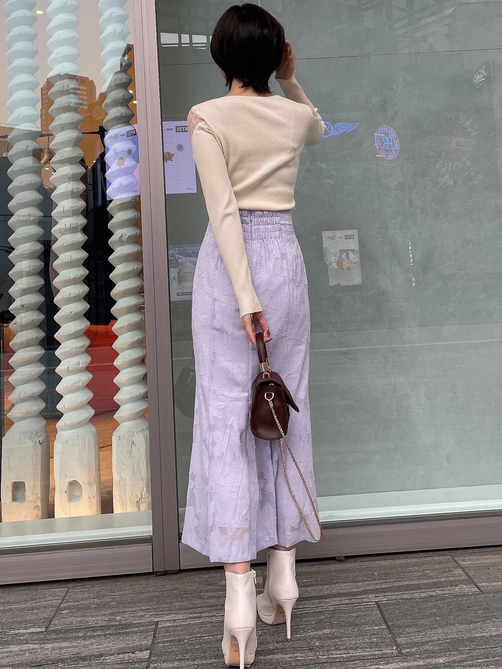 ホワイト系のブーツ、ブラウン系のハンドバッグ、ホワイト系のニット/セーターを着用したレディースの冬コーディネートの4枚目の写真