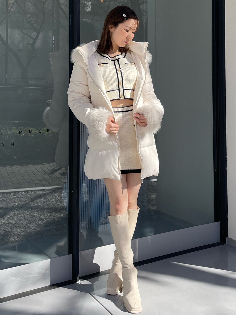 ホワイト系のダウンジャケット/コート、ホワイト系のニット/セーター、ホワイト系のスカートを着用したレディースの冬コーディネートの2枚目の写真