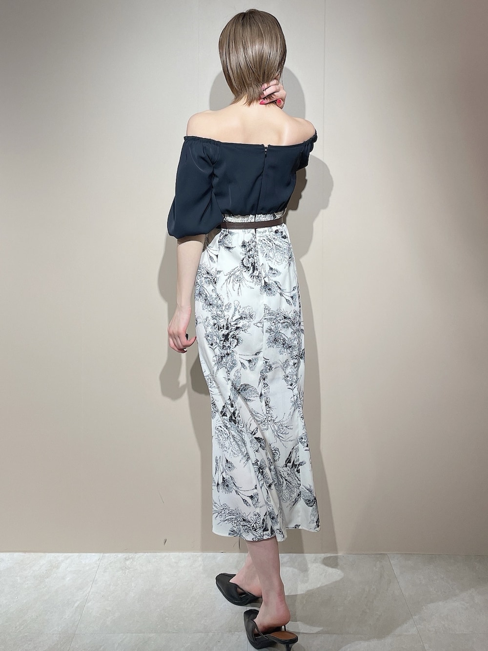 ブラック系のワンピース、ブラック系のパンプス、ブラウン系のベルトを着用したレディースの春コーディネートの6枚目の写真