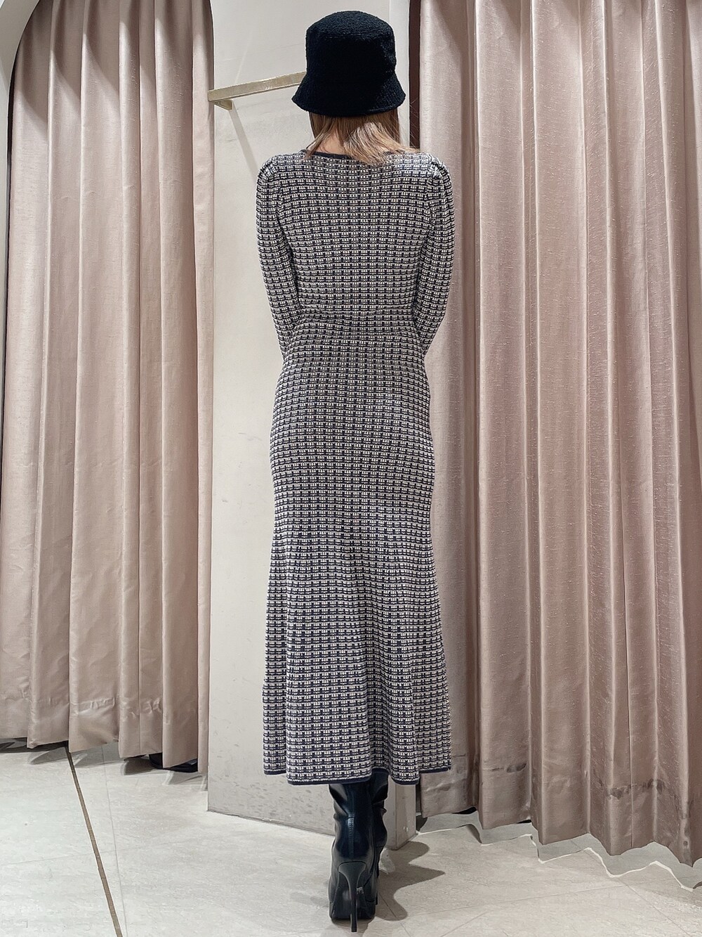 ブラック系のダウンジャケット/コート、ブルー系のワンピース、ブラック系のブーツを着用したレディースの冬コーディネートの6枚目の写真