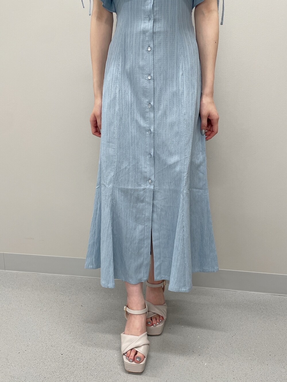 ブルー系のシャツワンピース、ベージュ系のサンダルを着用したレディースの春コーディネートの7枚目の写真