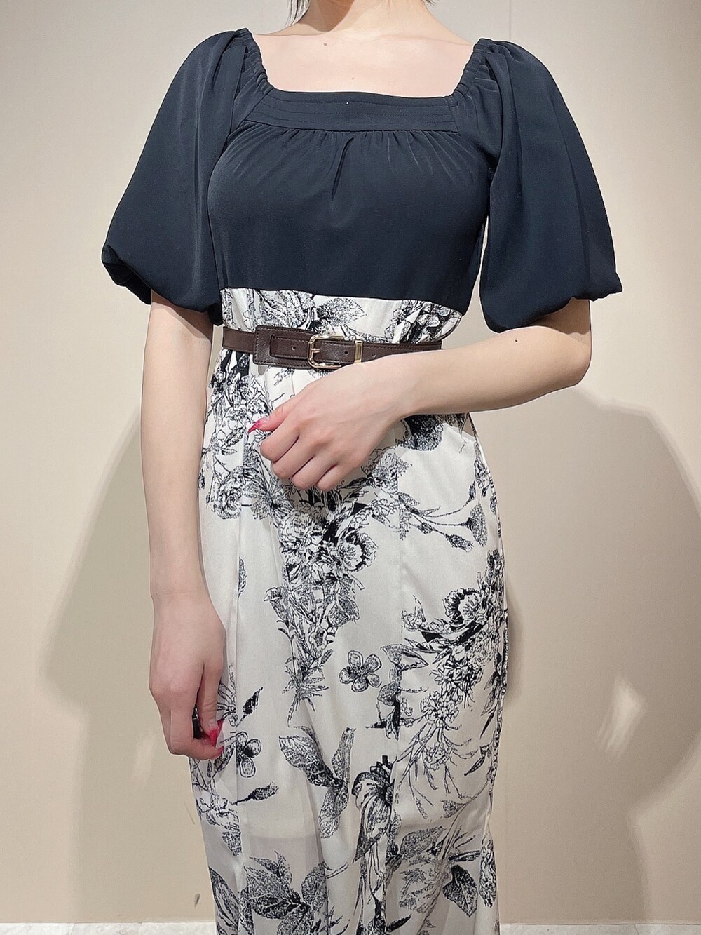 ブラック系のワンピース、ブラック系のパンプス、ブラウン系のベルトを着用したレディースの春コーディネートの7枚目の写真