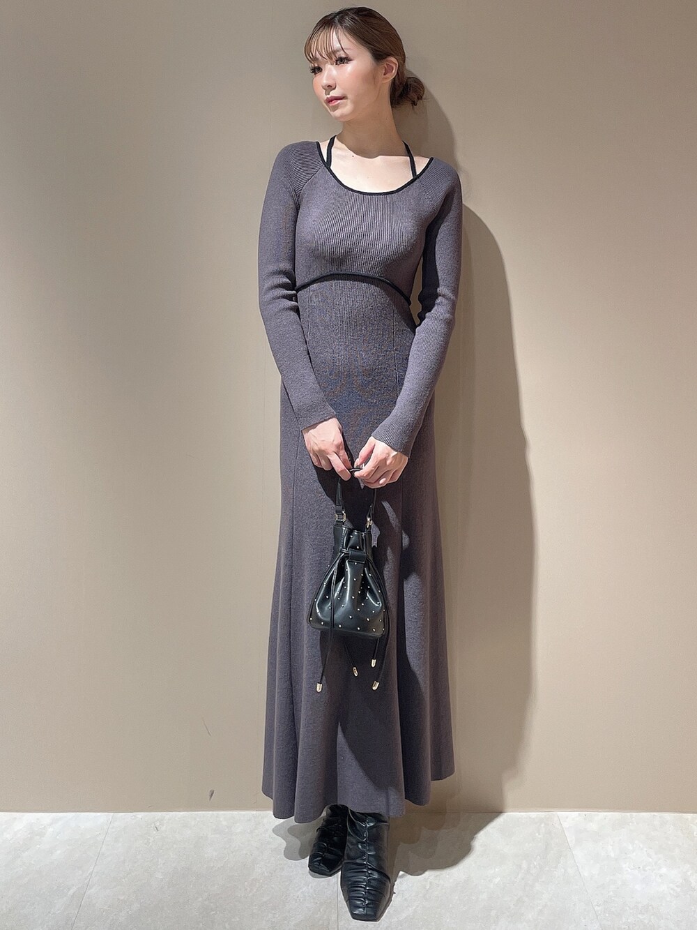 ブラック系のライダースジャケット、グレー系のワンピース、ブラック系のハンドバッグを着用したレディースの秋コーディネートの4枚目の写真