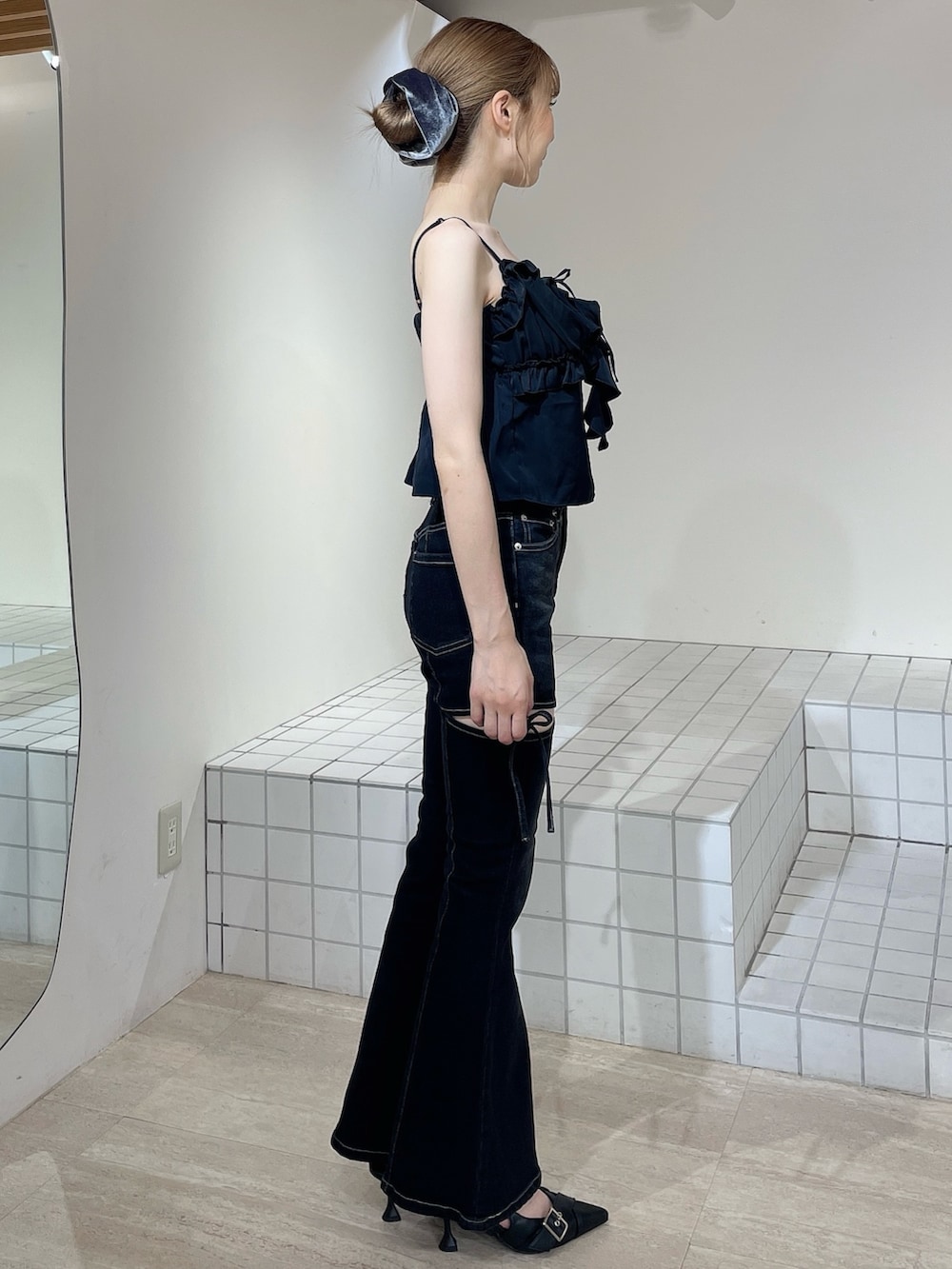 ブラック系のデニムパンツ、ブラック系のキャミソール、ブラック系のパンプスを着用したレディースの秋コーディネートの2枚目の写真