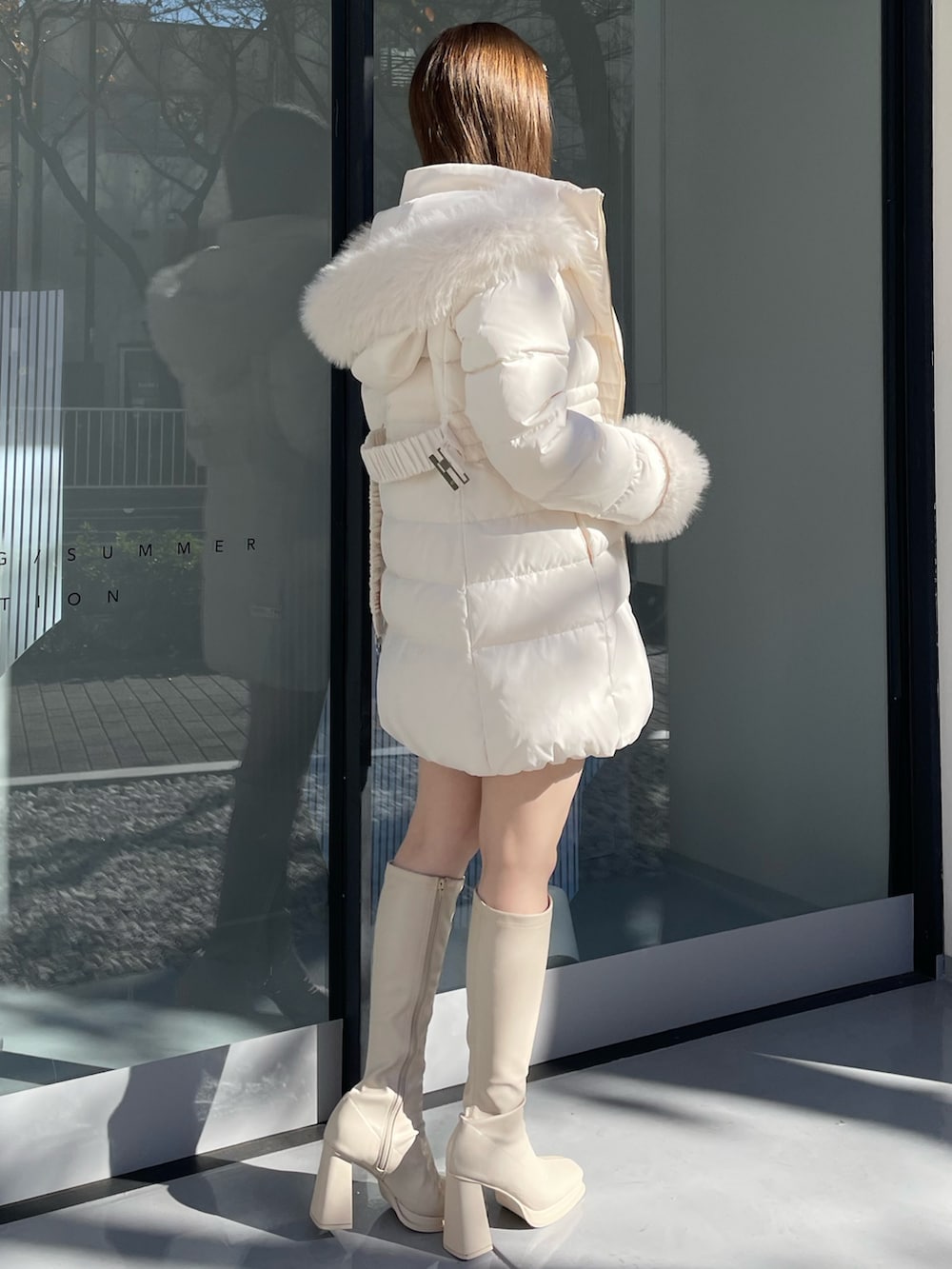 ホワイト系のダウンジャケット/コート、ホワイト系のニット/セーター、ホワイト系のスカートを着用したレディースの冬コーディネートの3枚目の写真