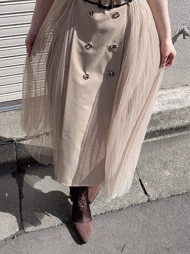 ベージュ系のワンピース、ブラウン系のブーツ、ゴールド系のネックレスを着用したレディースの春コーディネートの5枚目の写真