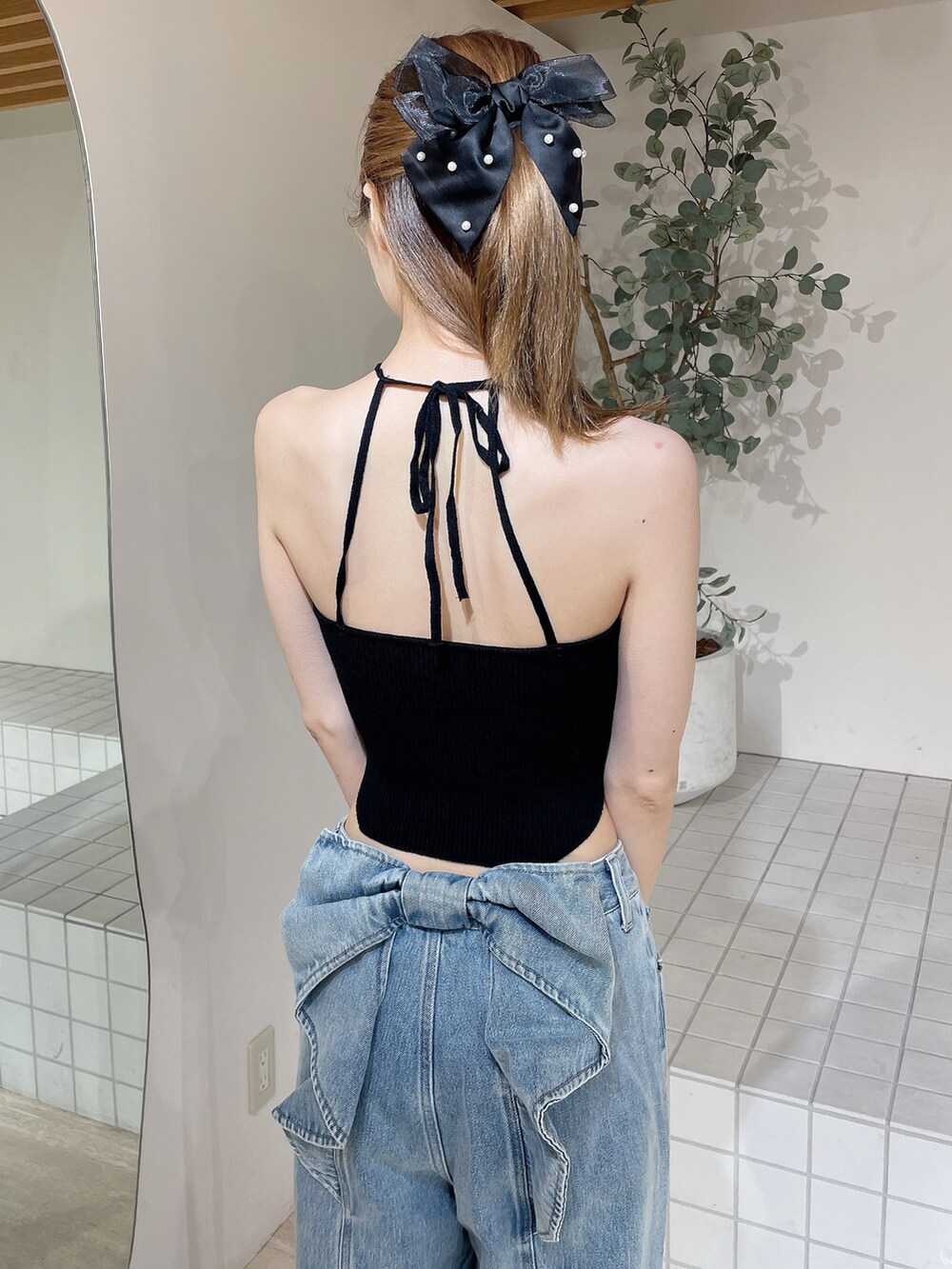 ブラック系のサンダル、ブラック系のキャミソール、ブルー系のデニムパンツを着用したレディースの夏コーディネートの7枚目の写真