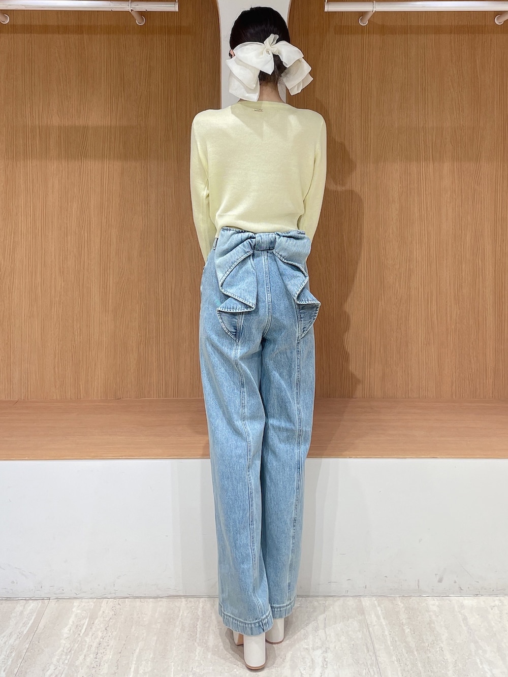 ホワイト系のテーラードジャケット、イエロー系のカーディガン/ボレロ、ブルー系のデニムパンツを着用したレディースの春コーディネートの6枚目の写真