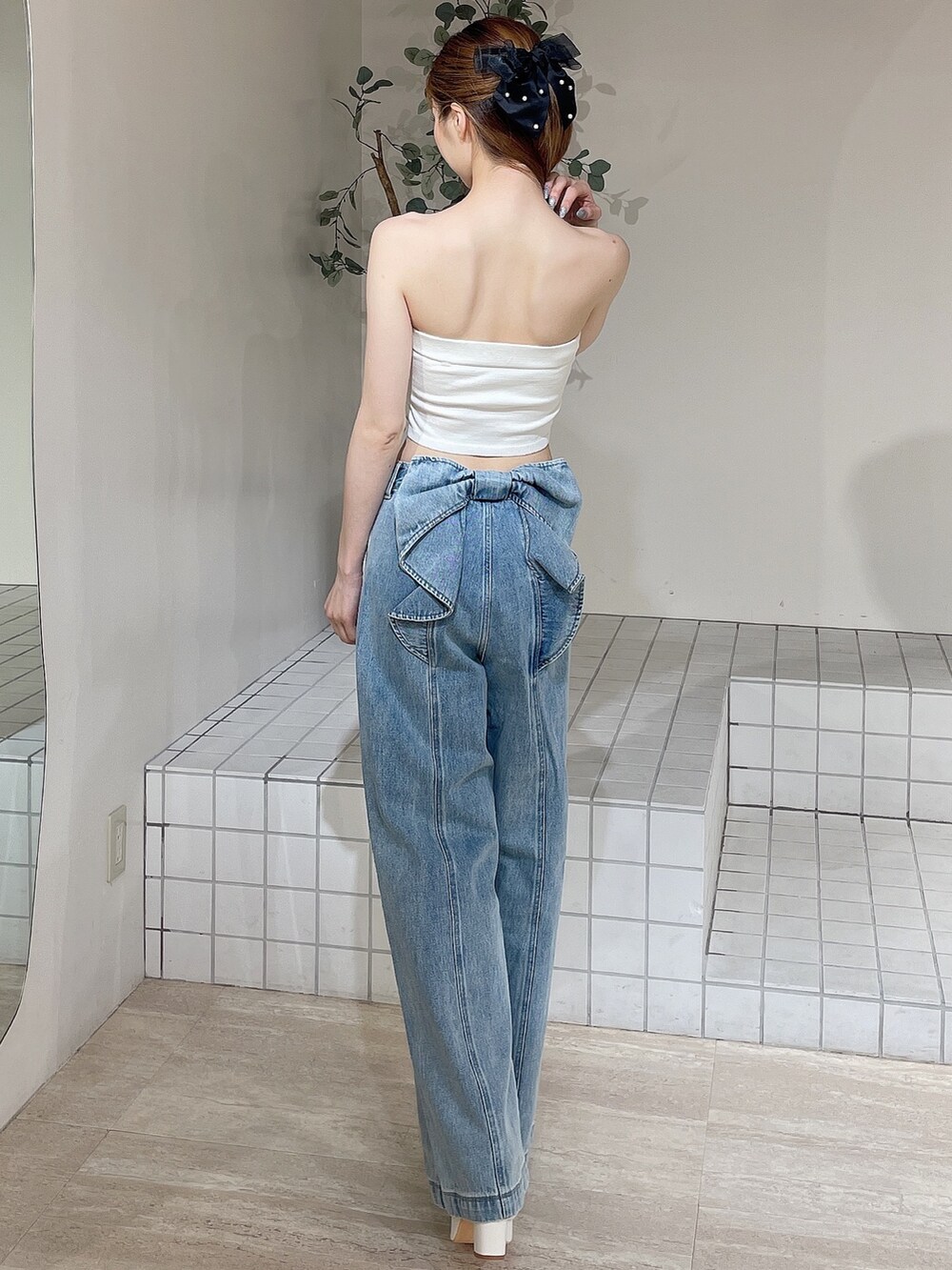 ホワイト系のサンダル、ブルー系のデニムパンツ、ホワイト系のキャミソールを着用したレディースの夏コーディネートの3枚目の写真