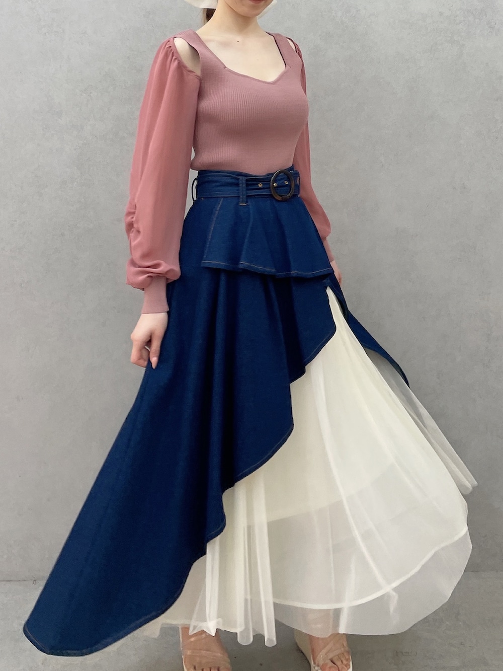 ピンク系のニット/セーター、ブルー系のスカート、ホワイト系のサンダルを着用したレディースの春コーディネートの3枚目の写真