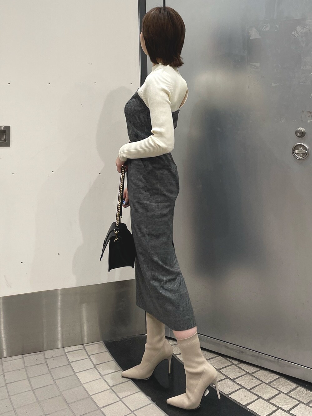 ホワイト系のブーツ、ブラック系のハンドバッグ、グレー系のその他アウターを着用したレディースの冬コーディネートの6枚目の写真