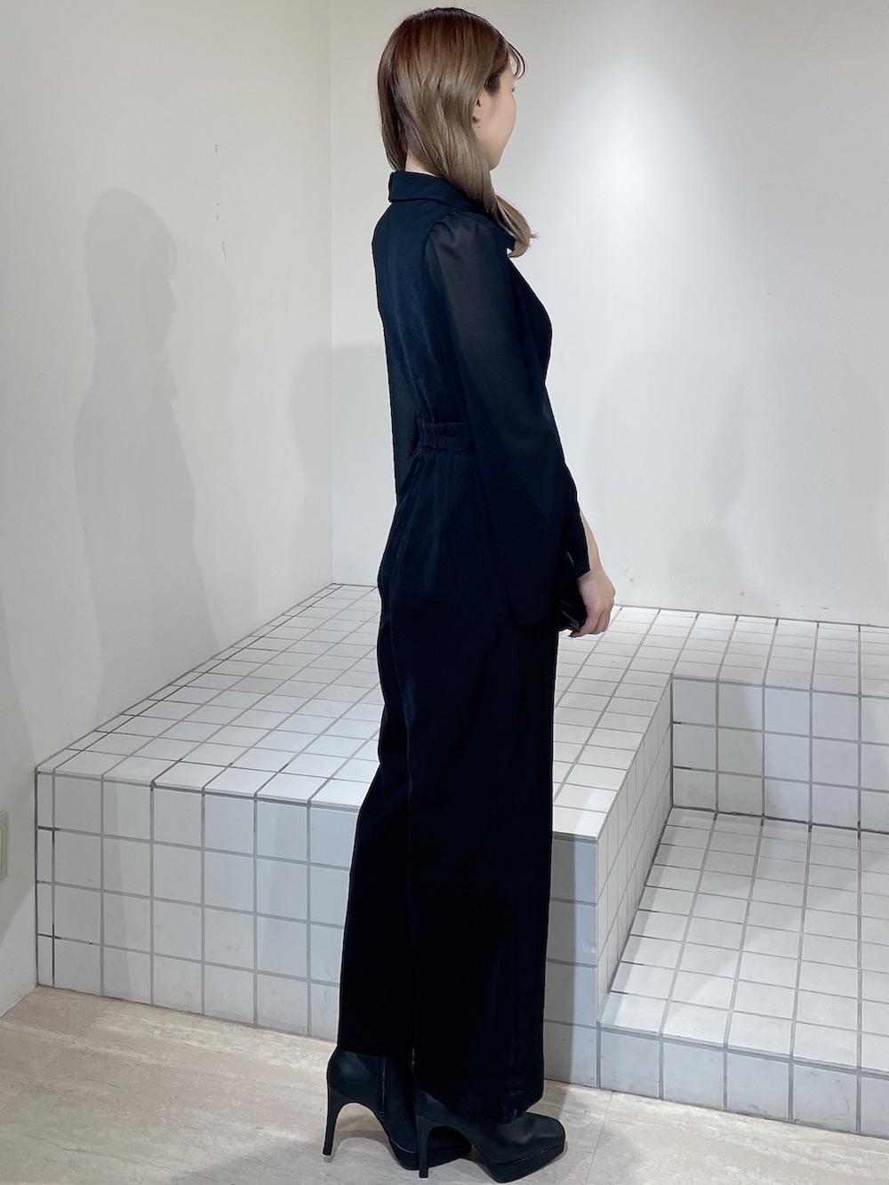 ブラック系のワンピース、ブラック系のブーツ、ブラック系のハンドバッグを着用したレディースの冬コーディネートの3枚目の写真