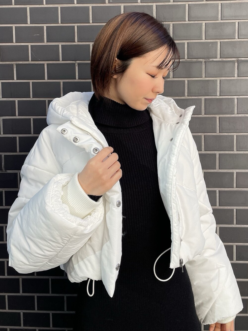 ブラック系のワンピース、ホワイト系のブルゾン、ホワイト系のスニーカーを着用したレディースの冬コーディネートの8枚目の写真