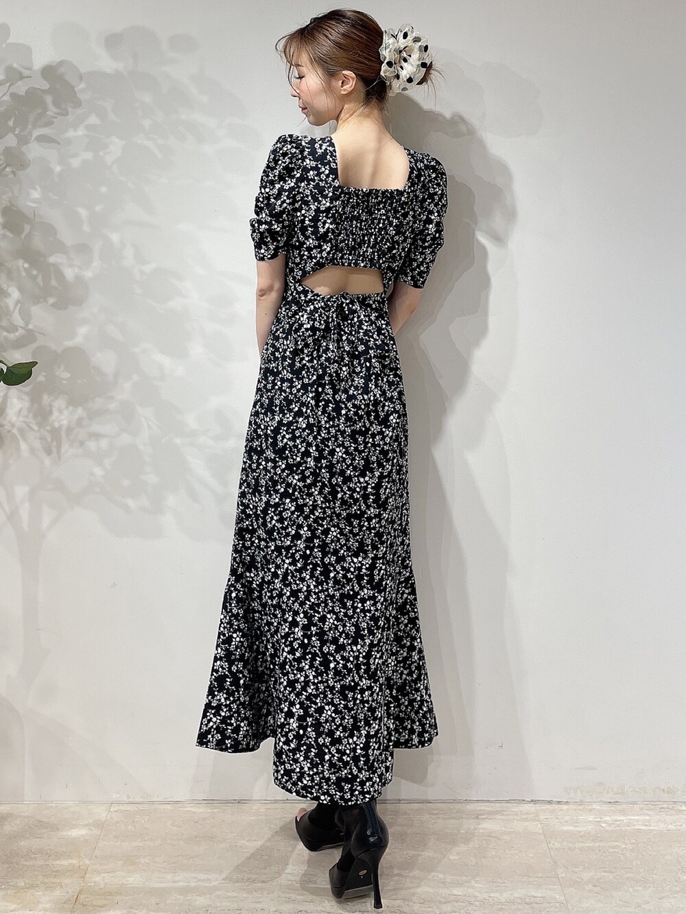 ブラック系のワンピース、ブラック系のブーツ、ベージュ系のシュシュを着用したレディースの春コーディネートの4枚目の写真