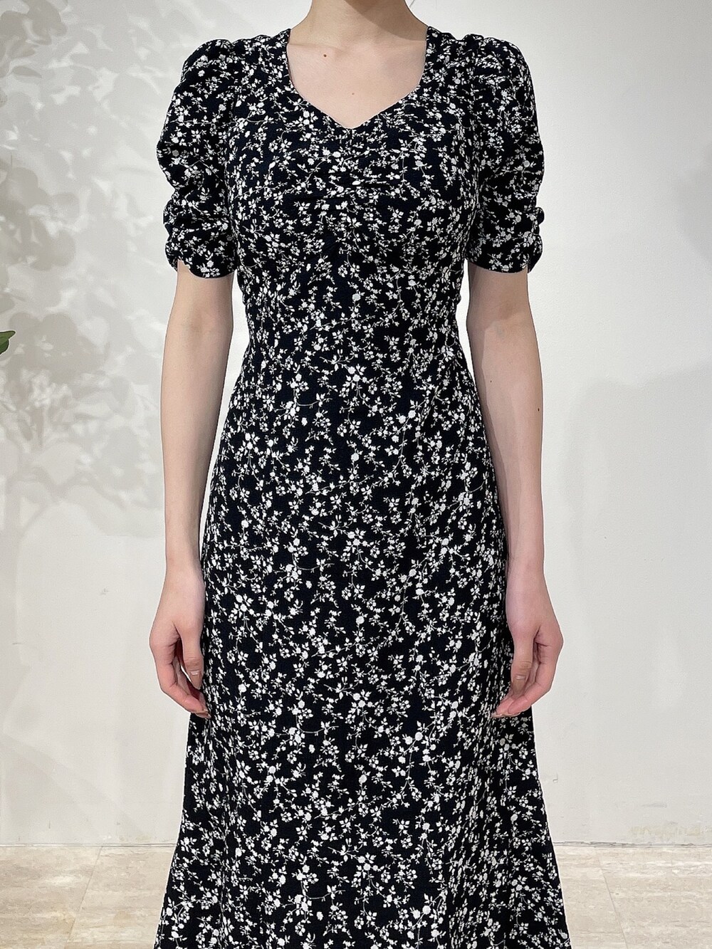 ブラック系のワンピース、ブラック系のブーツ、ベージュ系のシュシュを着用したレディースの春コーディネートの5枚目の写真