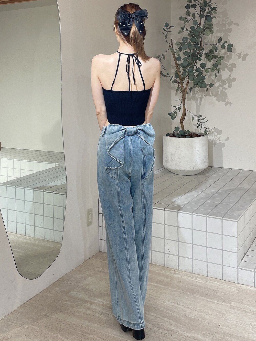 ブラック系のサンダル、ブラック系のキャミソール、ブルー系のデニムパンツを着用したレディースの夏コーディネートの4枚目の写真