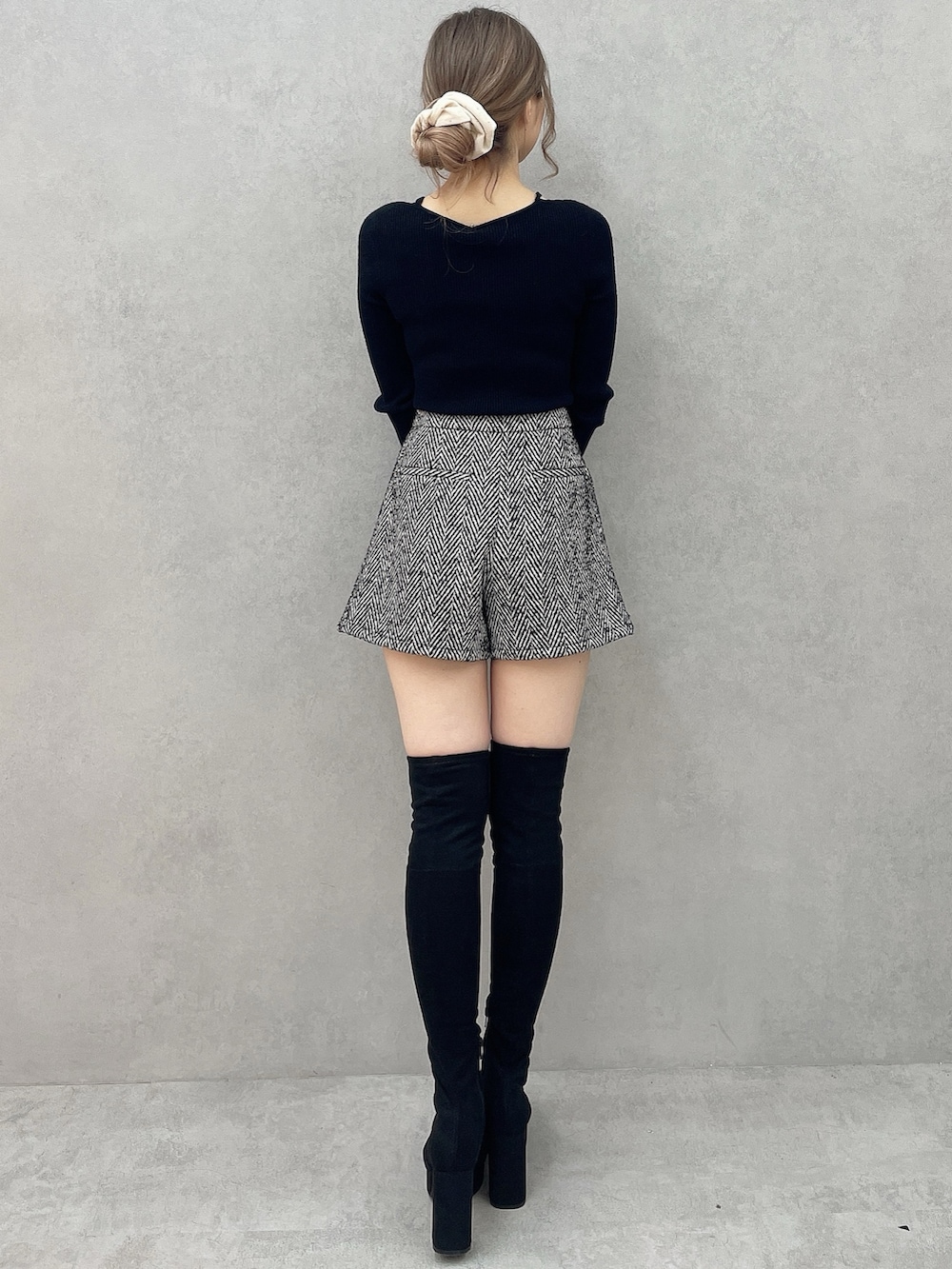 ブラック系のブーツ、ブラック系のニット/セーター、ブラック系のその他パンツを着用したレディースの秋コーディネートの7枚目の写真