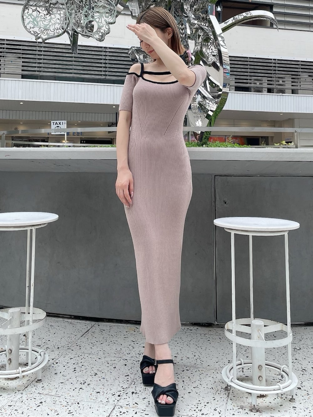 ベージュ系のワンピース、ブラック系のサンダルを着用したレディースの春コーディネートの2枚目の写真