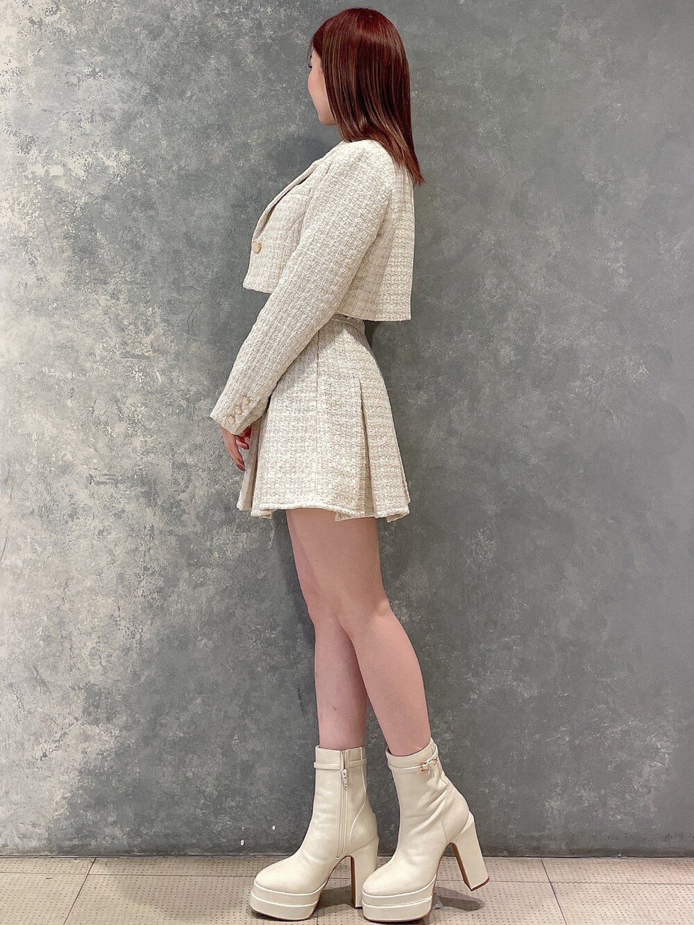 ホワイト系のテーラードジャケット、ホワイト系のスカート、ブラック系のニット/セーターを着用したレディースの冬コーディネートの3枚目の写真