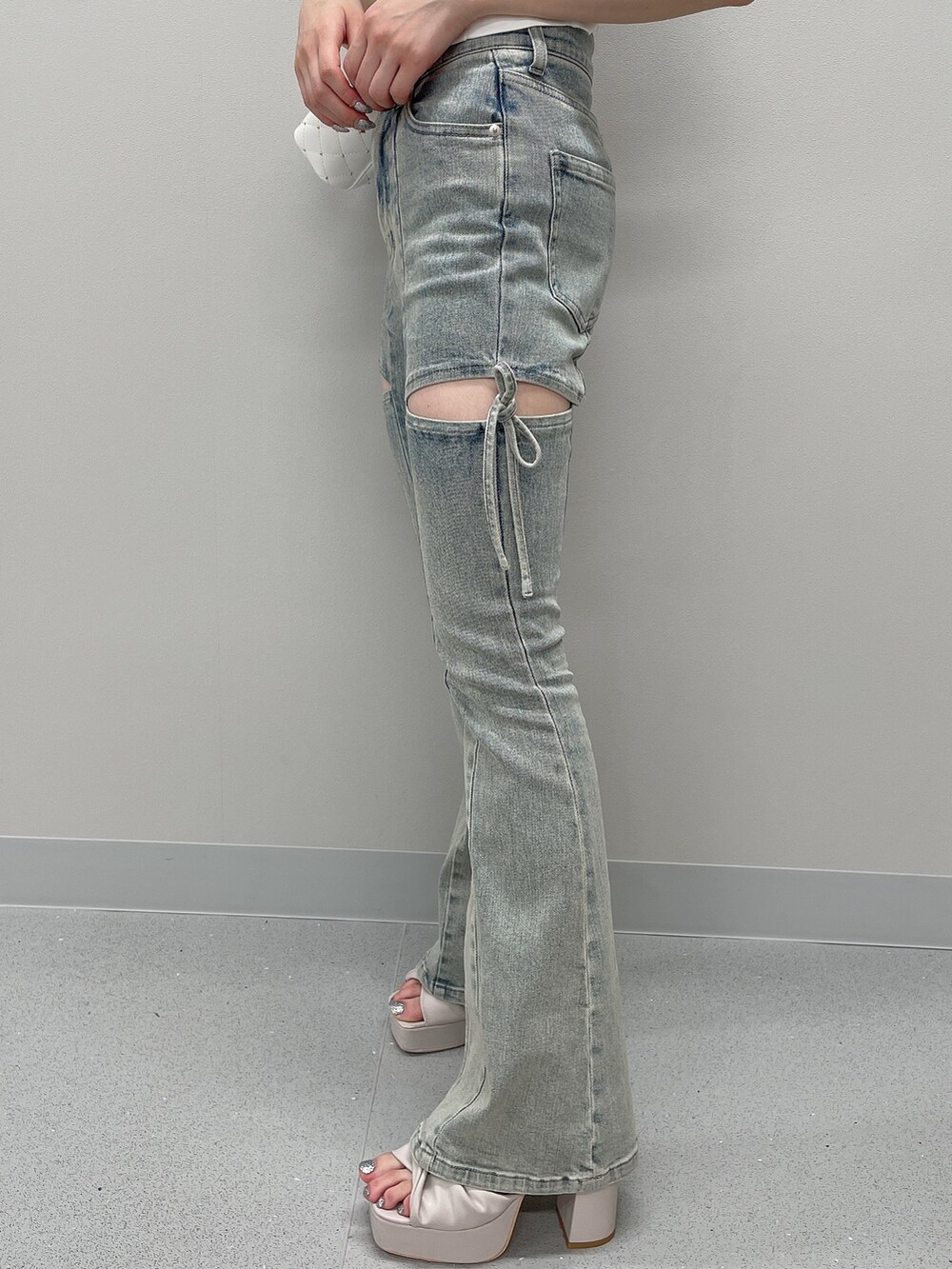 ピンク系のニット/セーター、ブルー系のデニムパンツ、ブラック系のサンダルを着用したレディースの春コーディネートの6枚目の写真