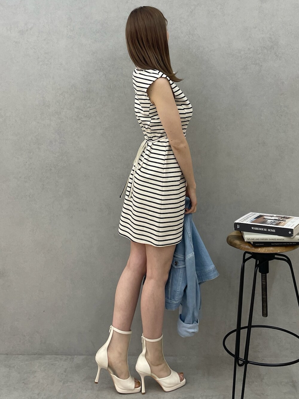 ホワイト系のワンピース、ホワイト系のブーツ、ブルー系のデニムジャケットを着用したレディースの春コーディネートの3枚目の写真