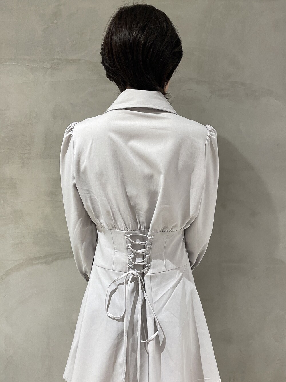 ブラウン系のハンドバッグ、ホワイト系のブーツ、グレー系のシャツワンピースを着用したレディースの冬コーディネートの5枚目の写真