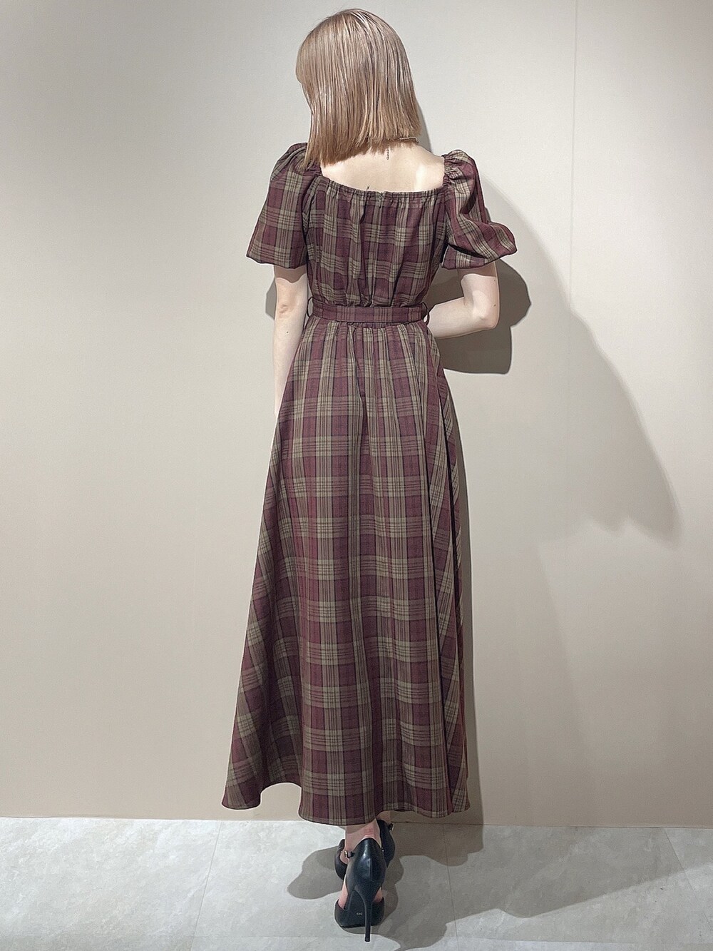 レッド系のワンピース、ブラック系のパンプス、ゴールド系のネックレスを着用したレディースの夏コーディネートの4枚目の写真