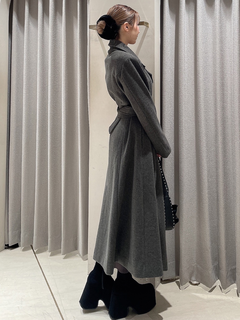 グレー系のその他アウター、ブラック系のブーツ、ブラック系のショルダーバッグを着用したレディースの秋コーディネートの3枚目の写真