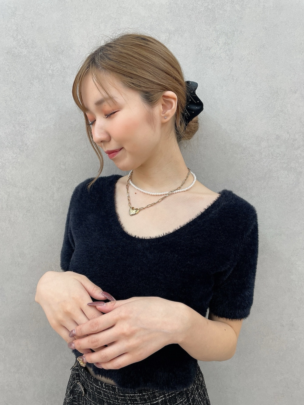 ブラック系のニット/セーター、ブラック系のスカート、ブラック系のシュシュを着用したレディースの夏コーディネートの4枚目の写真