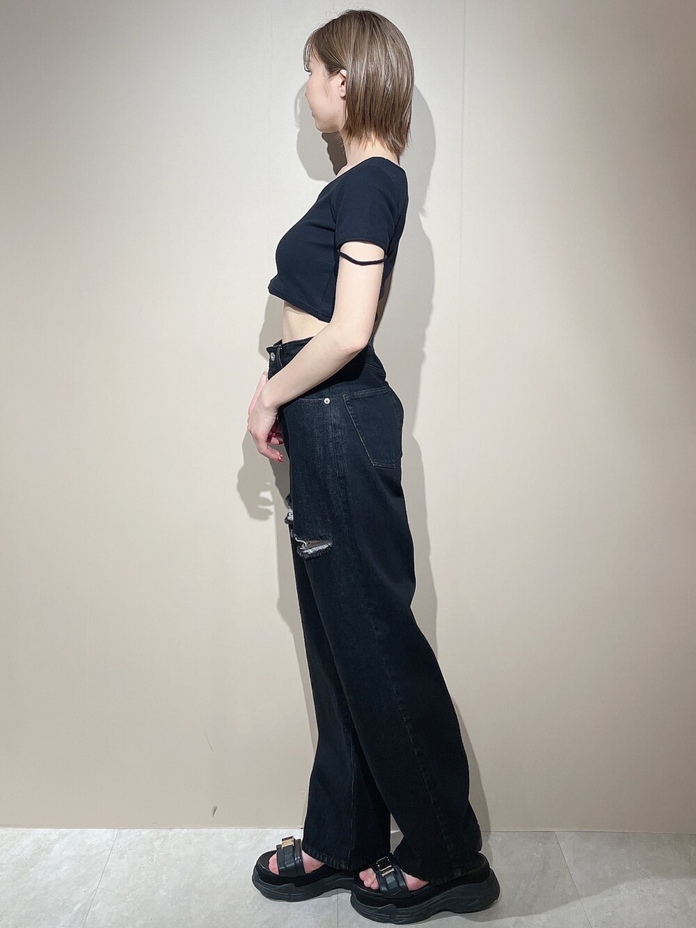 ブラック系のTシャツ/カットソー、ブラック系のデニムパンツ、ブラック系のサンダルを着用したレディースの春コーディネートの3枚目の写真
