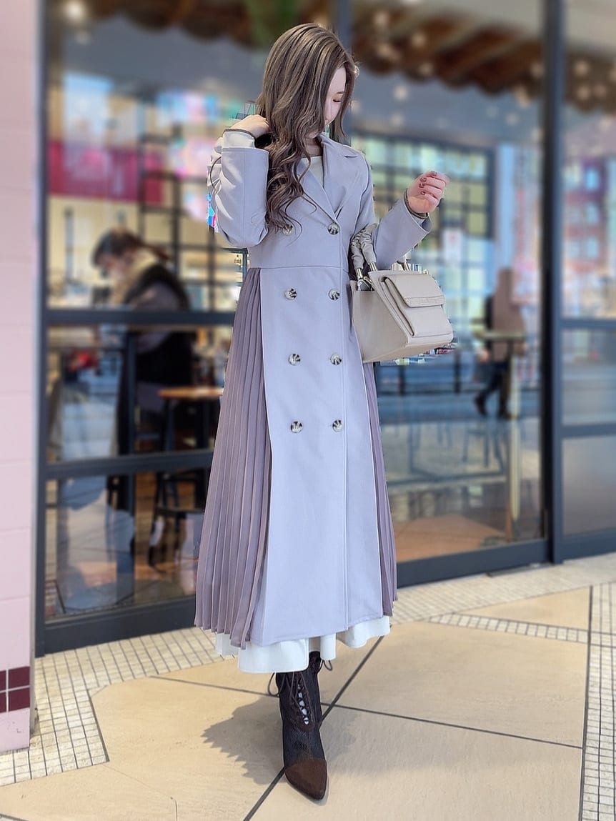 ベージュ系のワンピース、パープル系のトレンチコート、ブラウン系のブーツを着用したレディースの冬コーディネートの2枚目の写真