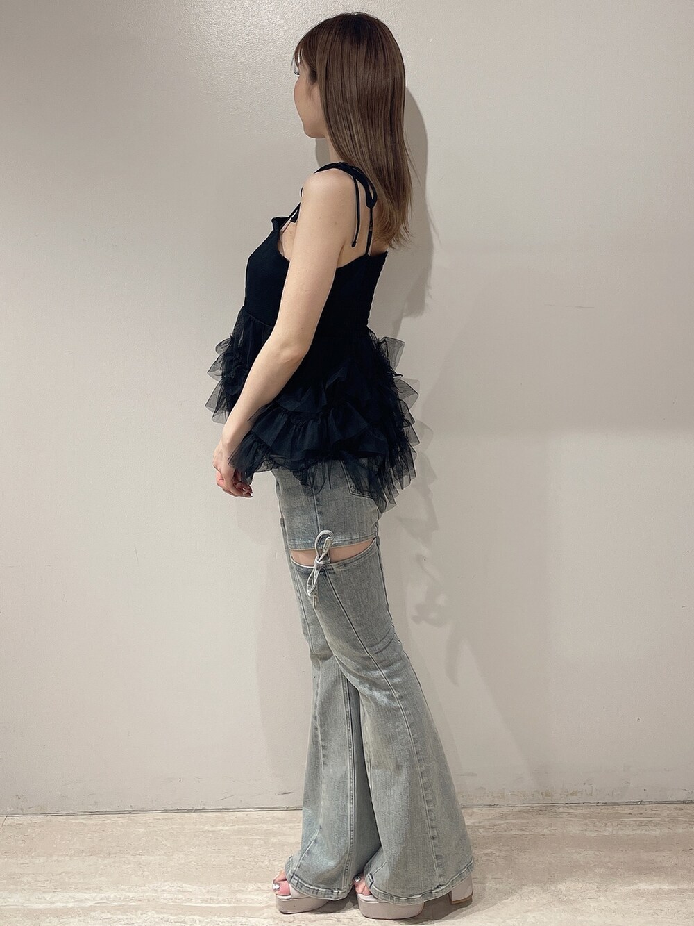 ブラック系のキャミソール、ブルー系のデニムパンツ、ベージュ系のサンダルを着用したレディースの夏コーディネートの3枚目の写真