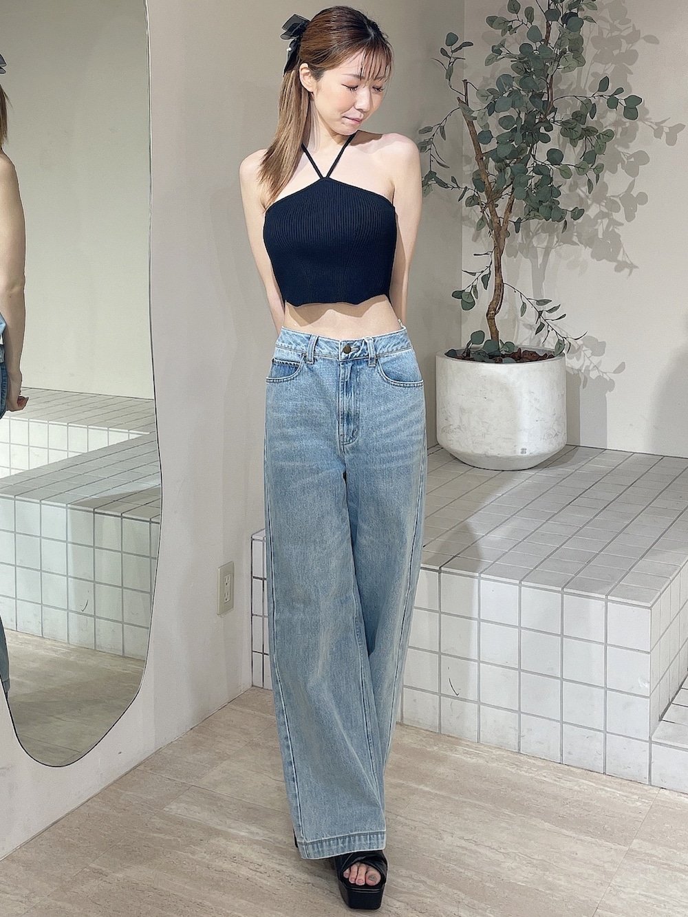 ブラック系のサンダル、ブラック系のキャミソール、ブルー系のデニムパンツを着用したレディースの夏コーディネートの2枚目の写真