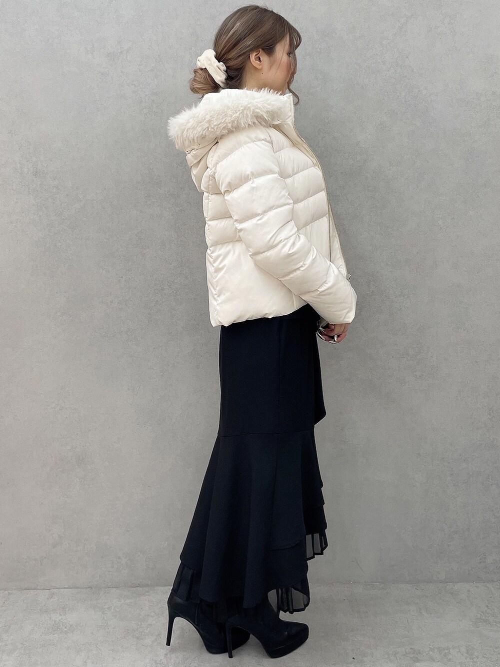 ホワイト系のダウンジャケット/コート、ホワイト系のニット/セーター、ブラック系のスカートを着用したレディースの秋コーディネートの2枚目の写真