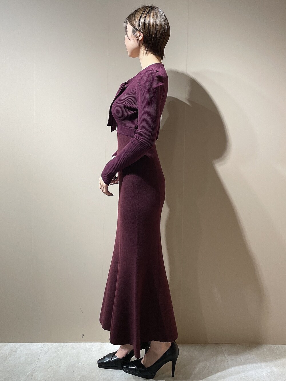 レッド系のワンピース、ブラック系のパンプスを着用したレディースの秋コーディネートの4枚目の写真